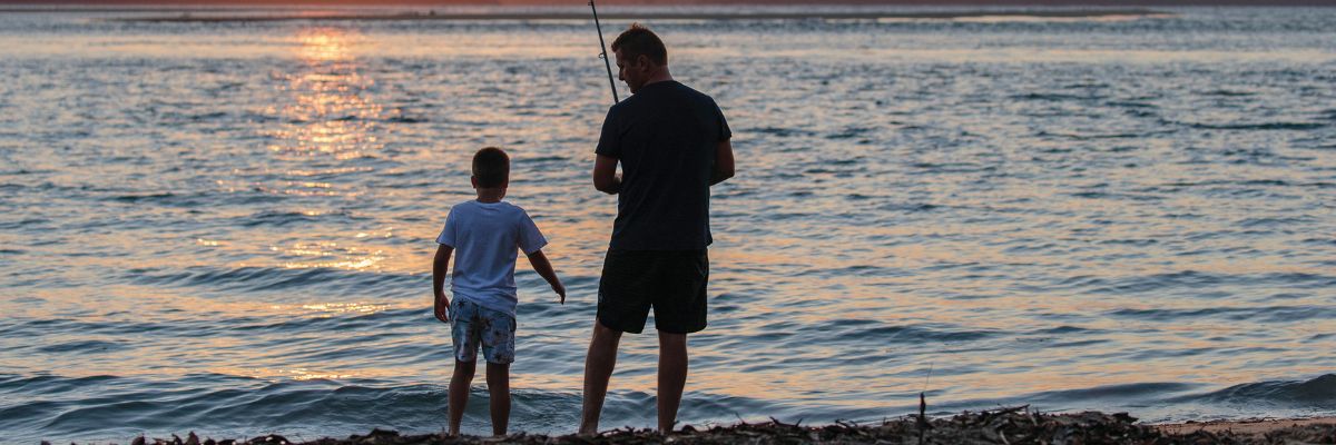 man and son fishing on beach
