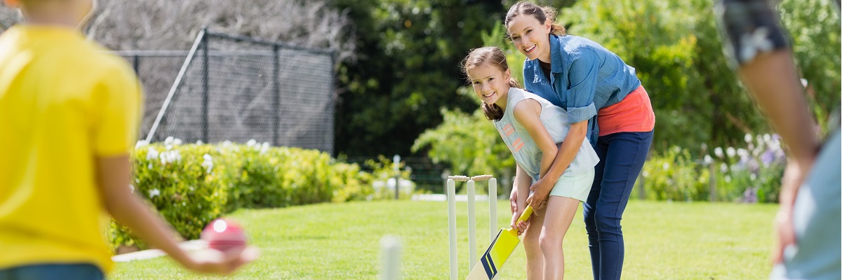kids and family paying cricket on the beach