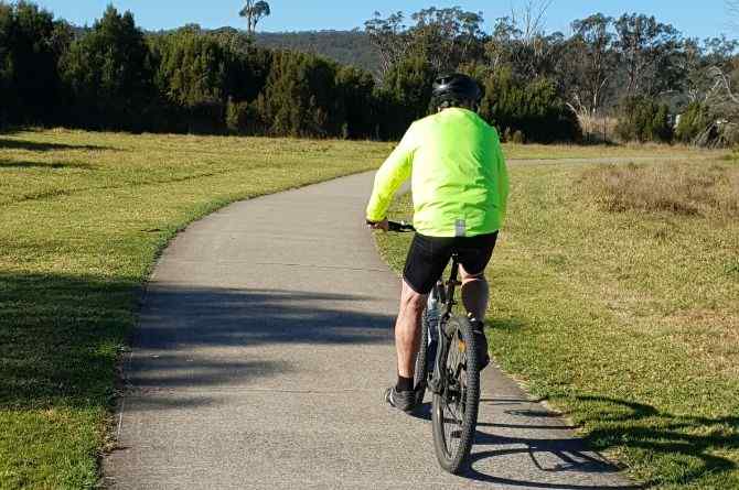 person on bike riding along bath 