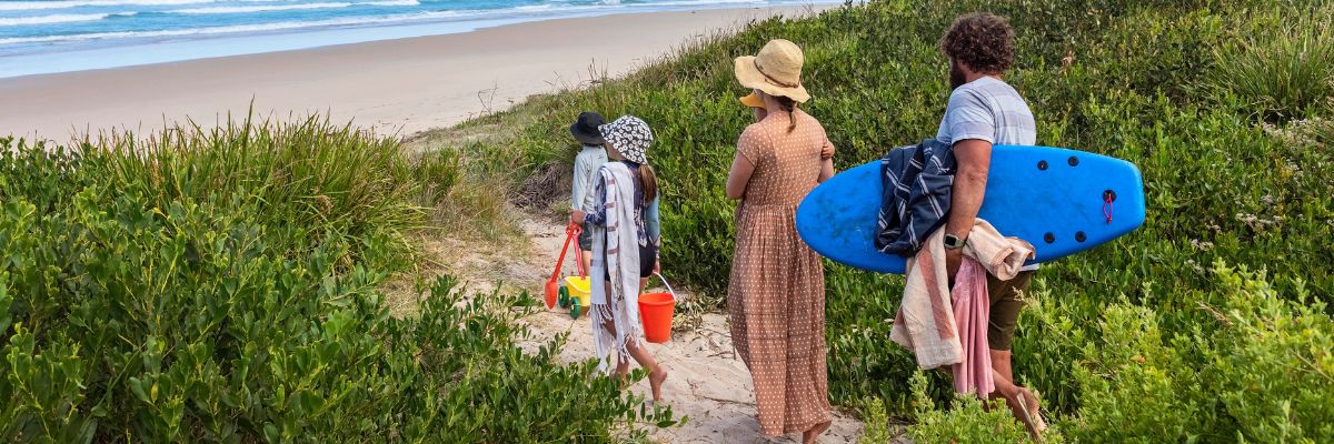family walking towards a beach