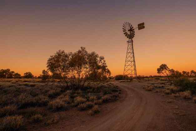 greg sullavan picture of sunset windmill and bush in the outback of the northern territory
